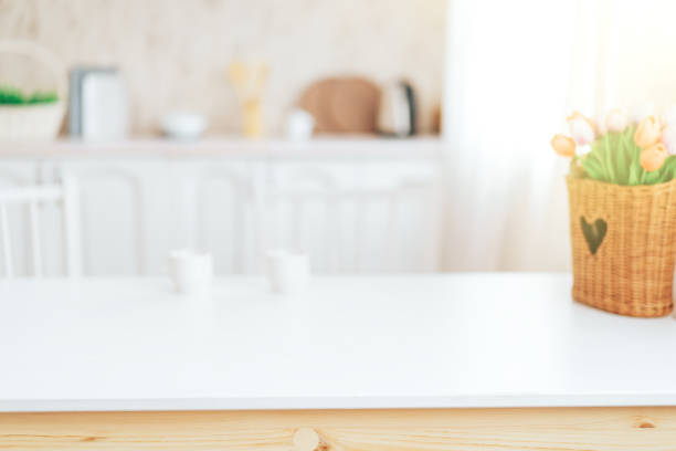 Wooden table with grass in front of blurred kitchen