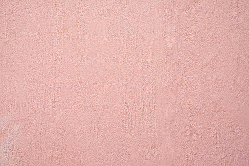 Abstract weathered texture stained old stucco light pink and aged paint concrete wall background in the room. This photo can be used for Valentine's Day concept.