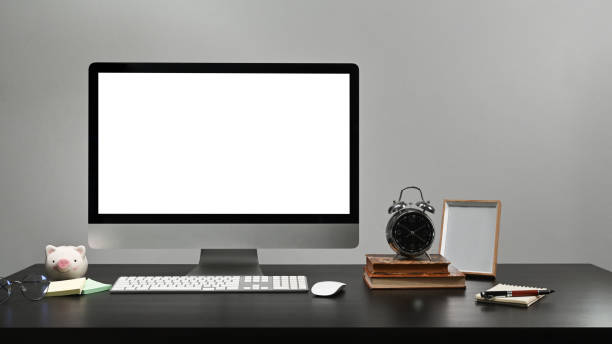 istock Modern home office with computer, books, picture frame and piggy bank on black table. 1365984081