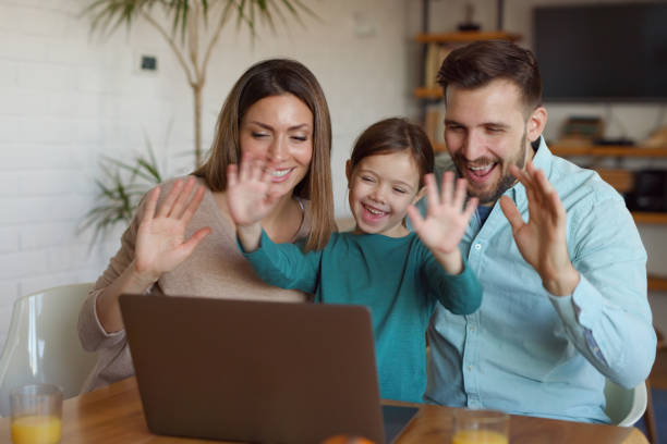 istock Happy family using laptop and making video call at home 1365986199