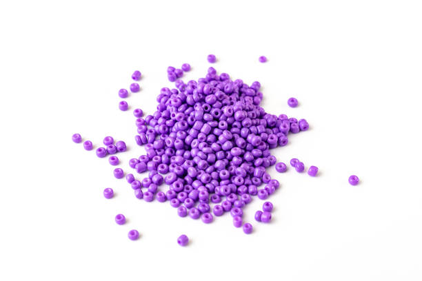 istock purple beads are scattered on a white surface. 1365986971