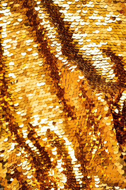 istock Golden sequins macro background. Sparkling sequined textile. Abstract texture scales with shiny sequins on fabric. 1365987059