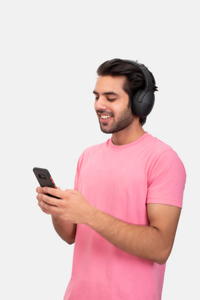 istock Young man using phone and listening music on headphone 1365989480