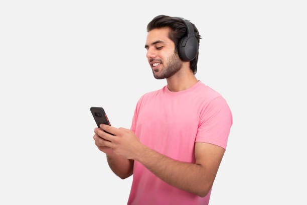 istock Young man using phone and listening music on headphone 1365989490