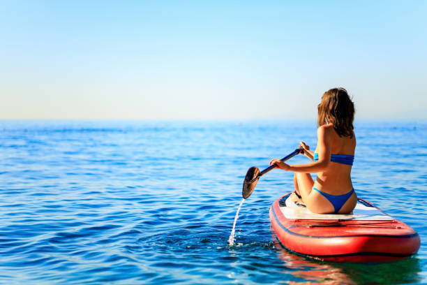 istock Woman paddling on sup board with mountains on background 1365991699
