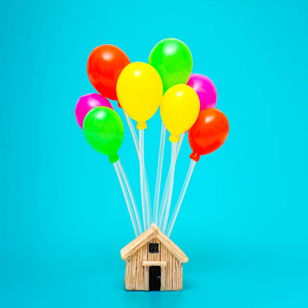 istock Toy house with multicolored balloons on blue 1365991706