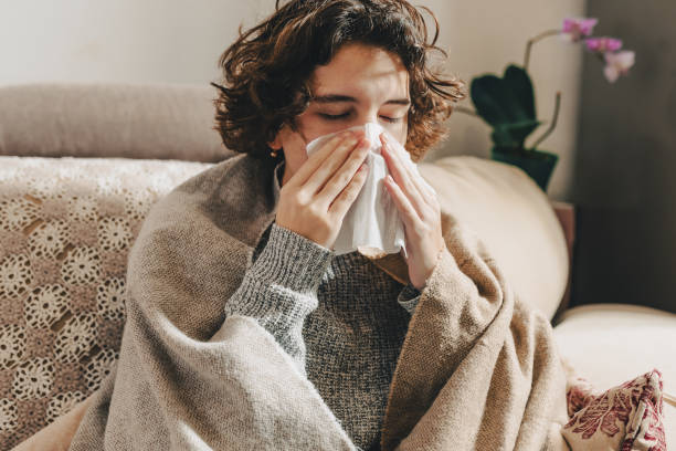 istock young woman blowing her nose 1365991846