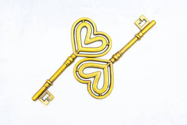 istock Brass heart shaped keys on a neutral background 1365991930