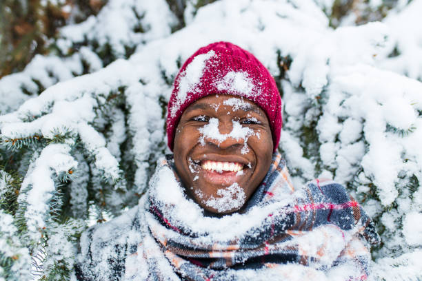 istock hispanic man in red hat with snowflake on face having fun and feeling christmas mood in park 1365997105