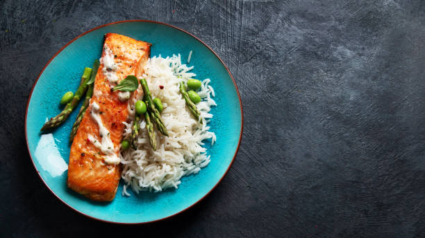 istock Baked salmon with rice and asparagus on gray background. 1365997259