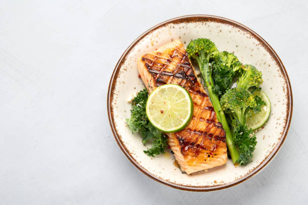 istock Baked salmon with vegetables on light background. 1365997886