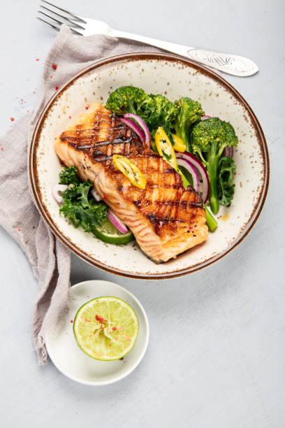 istock Baked salmon with vegetables on light background. 1365998004