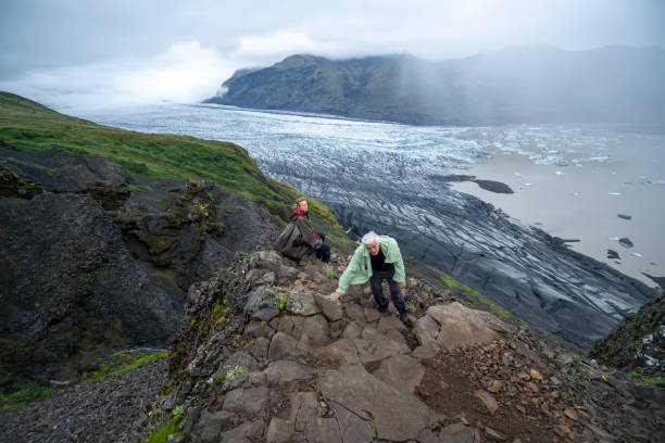 coppia senior che si arrampica sul ghiacciaio skaftafell nel parco nazionale del vatnajokull, islanda meridionale - skaftafell glacier foto e immagini stock
