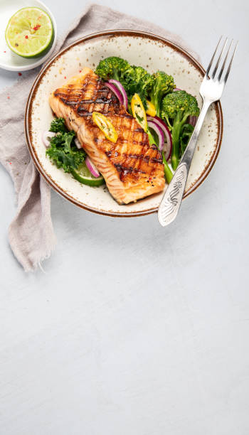istock Baked salmon with vegetables on light background. 1365998582
