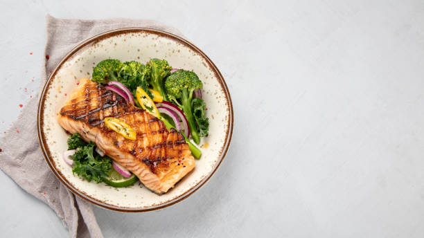 istock Baked salmon with vegetables on light background. 1365998584
