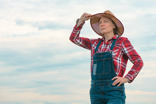 Portrait of concerned female farmer agronomist outdoors with sky as copy space