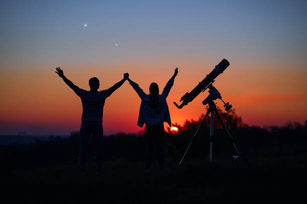 istock Couple stargazing together with a astronomical telescope. 1366003072