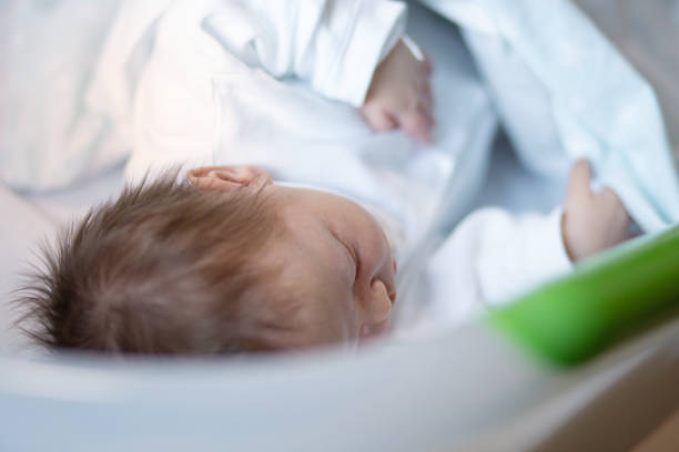 A newborn baby boy sleeping in his hospital crib.