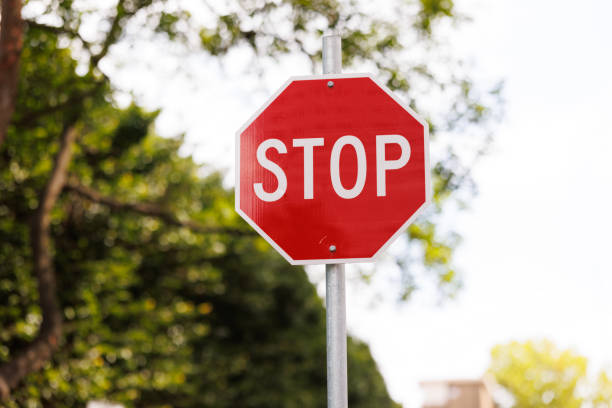 Red stop sign Red stop sign with foliage behind stop single word stock pictures, royalty-free photos & images