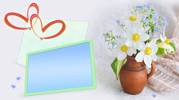 A text frame, hearts and a bouquet of flowers in a clay vase on a light background. Valentine's Day Concept stock photo