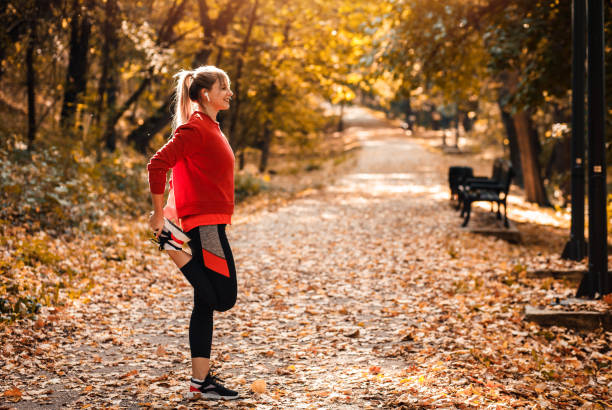 istock Young woman warming up and stretching before running in park. 1366009565