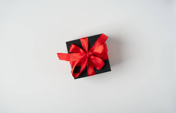 istock Black gift boxes with red ribbon on white background 1366009678