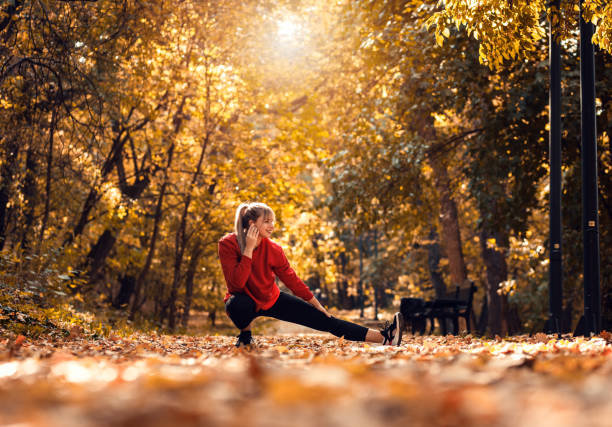 istock Young woman warming up and stretching before running in park. 1366009749