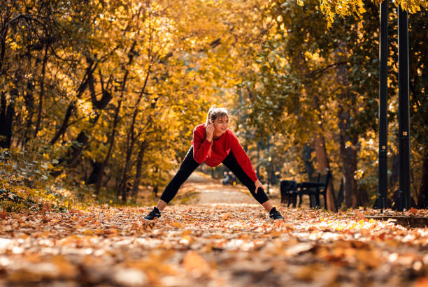 istock Young woman warming up and stretching before running in park. 1366009809
