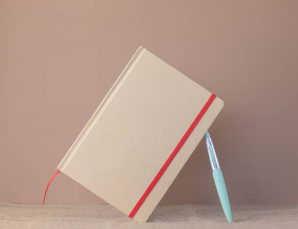 istock Recycled paper agenda with pen on pastel background 1366011624
