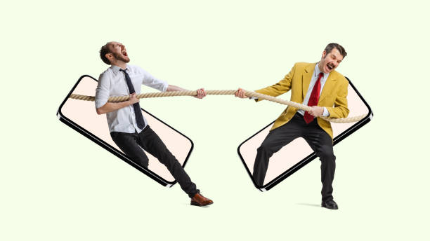 istock Collage. Two men, employees sticking out phone screen and pulling the rope symbolizing professional competition 1366011671