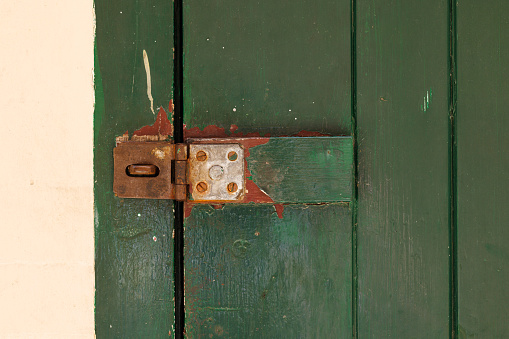 Detail of a wooden door with an old unlocked latch.