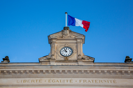 French tricolor flag with mairie liberte egalite fraternite france text building mean town hall and freedom equality fraternity in city center in france