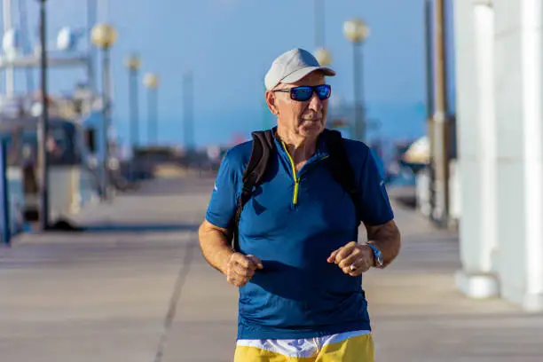 Photo of Senior man jogging on the wooden pier