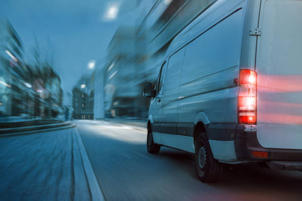 schneller lieferwagen fährt nachts in der stadt - overnight delivery stock-fotos und bilder