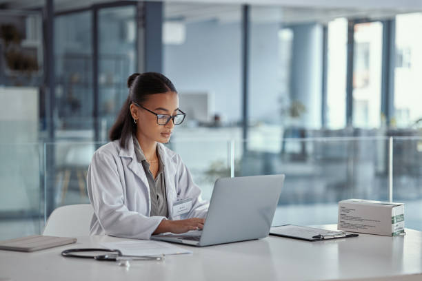 Shot of a young female doctor using a laptop at work stock photo