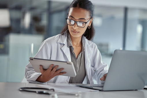 Shot of a young female doctor using a digital tablet at work