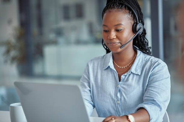 istock Shot of a young female call center agent using a laptop at work 1366016964