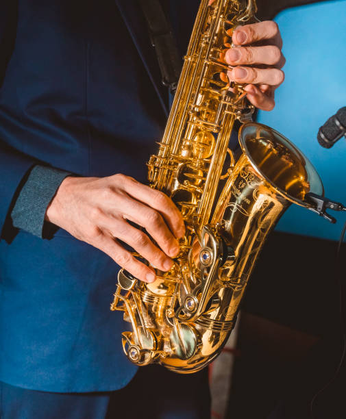istock hands of a man plays a saxophone with a microphone attached 1366017536