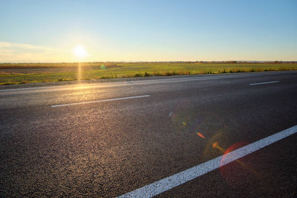 istock Empty intercity road with asphalt surface and white markings in evening 1366017812