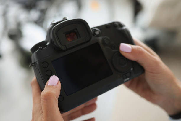 istock Female hands are holding a black modern camera 1366020195