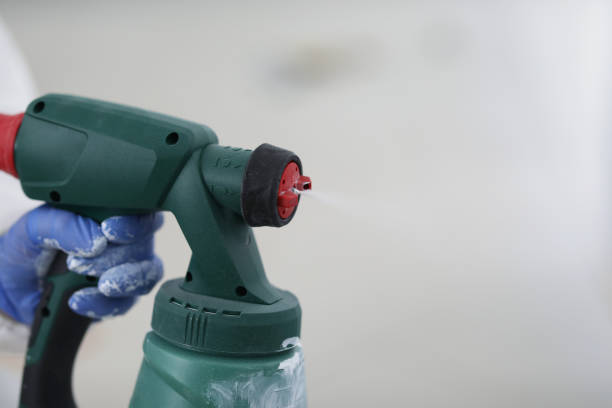 istock Spray gun in the hands of a builder, close-up 1366020207