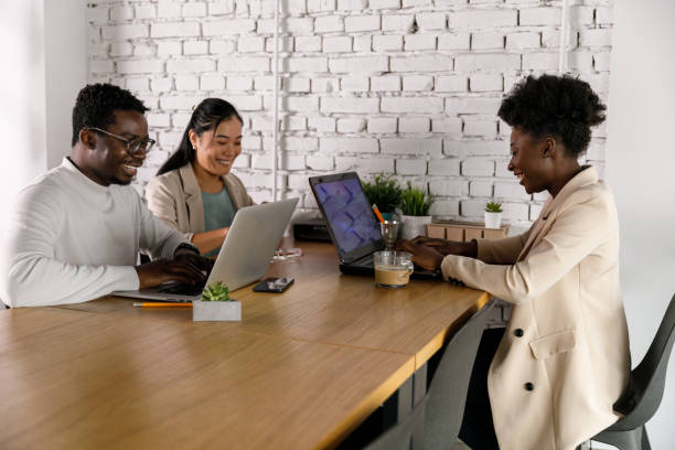 istock Three young business colleagues sitting at table and co-working on a project 1366021557