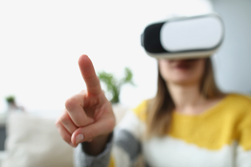 Woman wearing virtual glasses, close-up, blurry. Augmented reality touch, VR device, online training