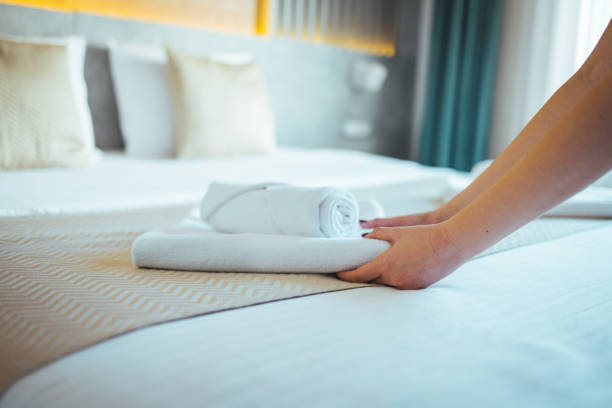 istock Female Hand set up white bed sheet in bedroom. 1366021630