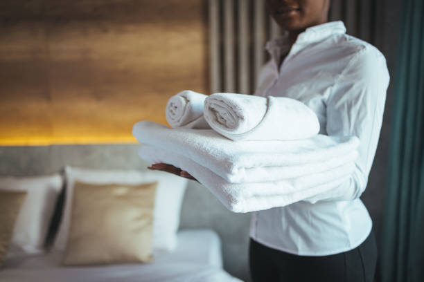 istock Young hotel maid making the bed with clean fresh towels. 1366021803