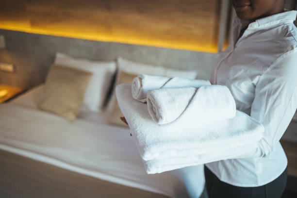 istock Young hotel maid making the bed with clean fresh towels. 1366021804