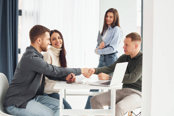 istock Four people works in the office by sitting by the table indoors 1366024422