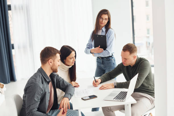 istock Four people works in the office by sitting by the table indoors 1366024430