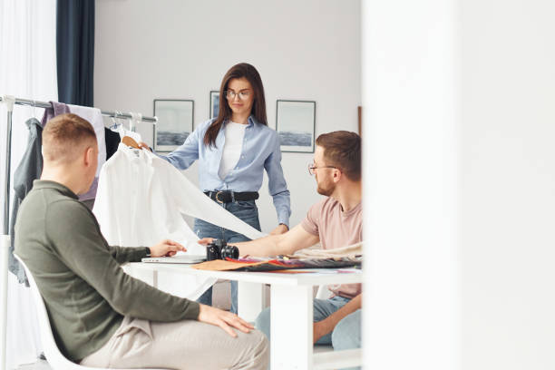 istock Working with cloth. Having conversation. Group of people works in the office 1366024922