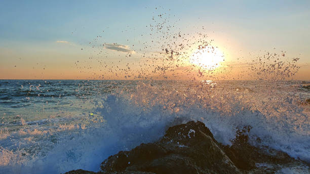 istock Colorful sunset with large sun under the sea waves. 1366027150